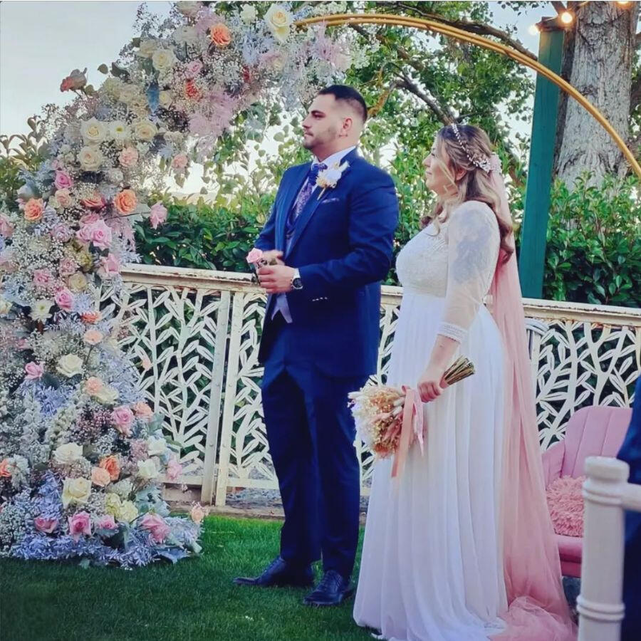 Arco de flores y pareja de novios